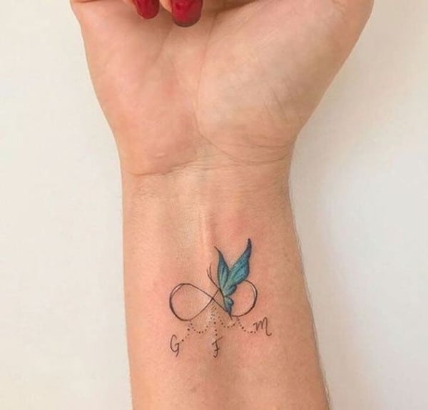 tatuaggio con farfalla blu e piccole linee tratteggiate