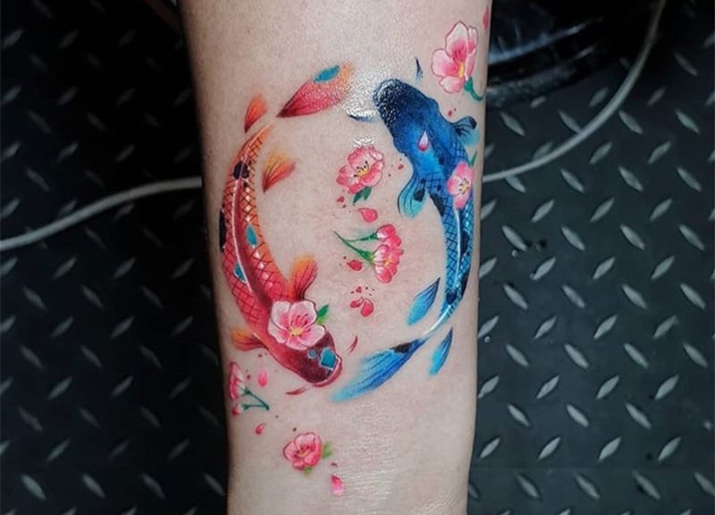 cherry blossom pisces tatttoo on the arm
