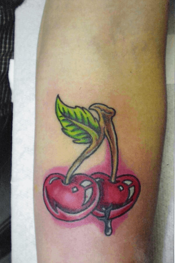 tatuaggio con ciliegia gocciolante sul braccio