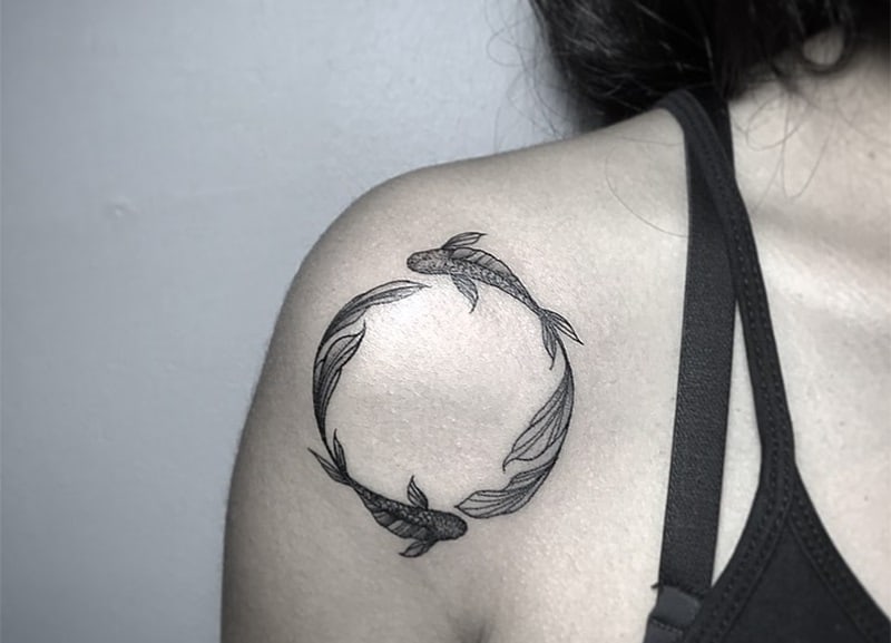 circle pisces tattoo on woman`s shoulder