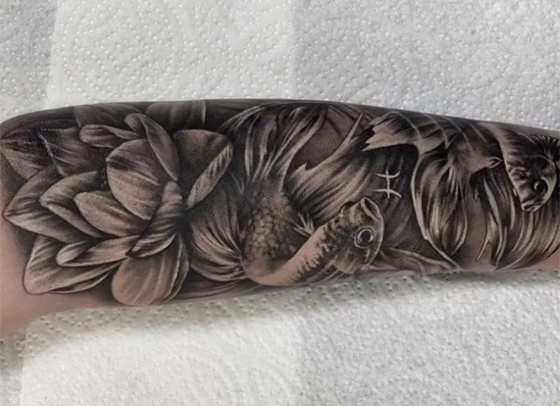 classic black and grey pisces tattoo enriched with water lilies