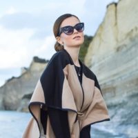 woman wears black and brown dress and sunglasses