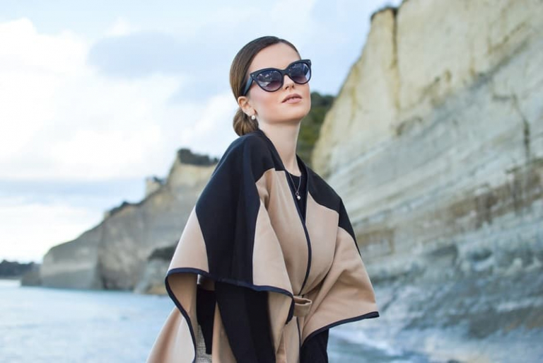 woman wears black and brown dress and sunglasses