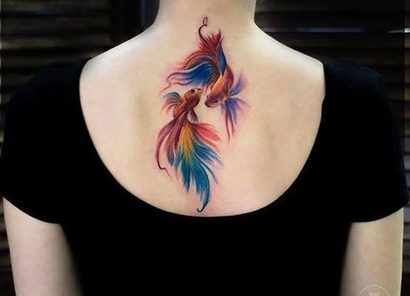 colored pisces tattoo on the back