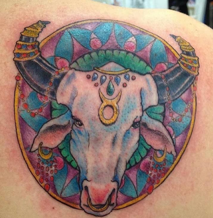 colorful taurus in the circle tattoo with gold details