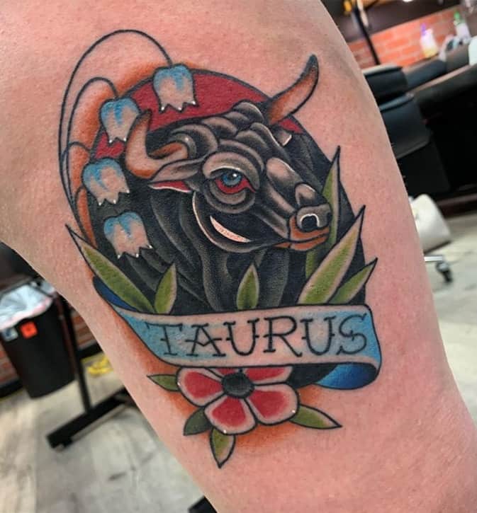 colorido tatuaje de tauro con flores en estilo tradicional americano