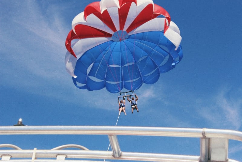 man and woman doing parasailing at daytime