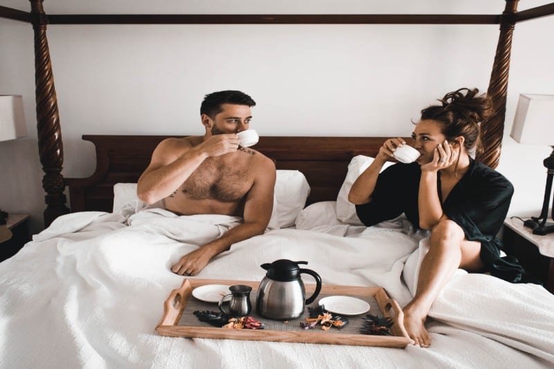 hombre y mujer tomando cafe en la cama
