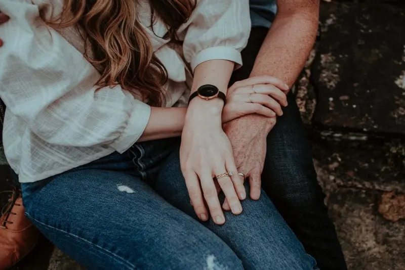 couple with wedding rings holding hands