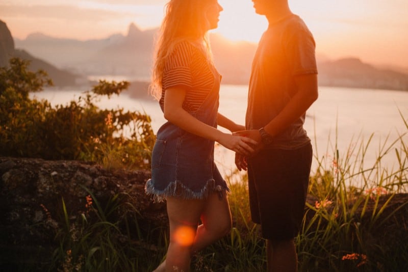 woman and man holding hands during sunset