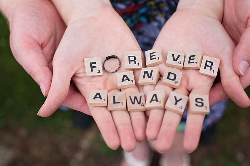 couple holding letter block on their palms