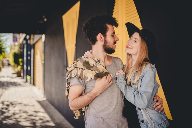 couple hugging near a black and yellow wall