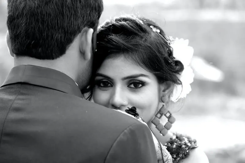 greyscale photo of man and woman hugging