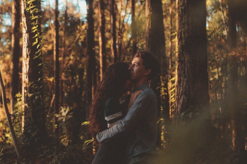 man and woman hugging in forest