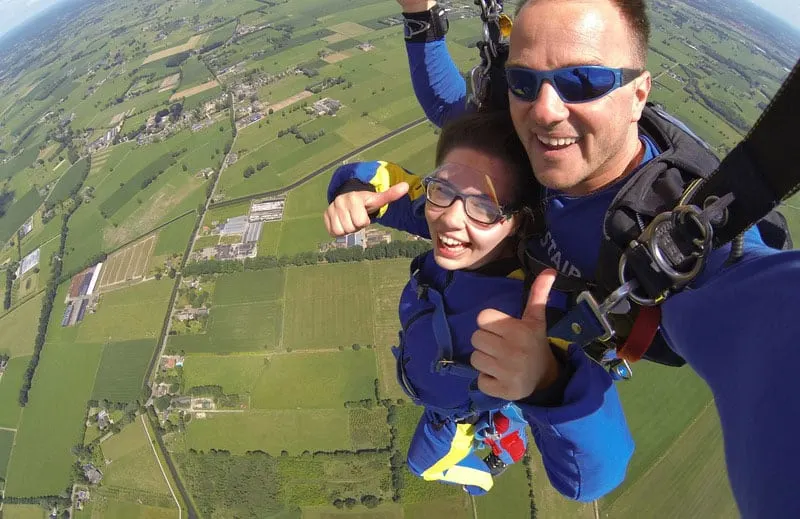 couple in paragliding wearing blue suit