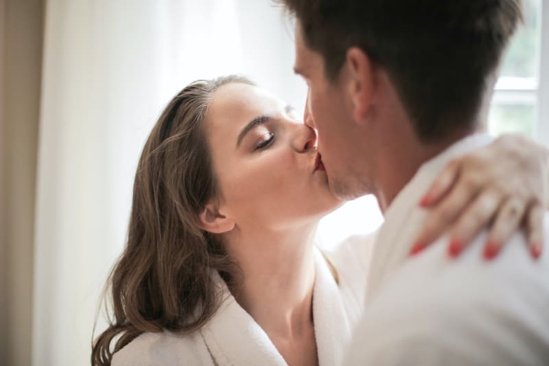 man and woman kissing indoor