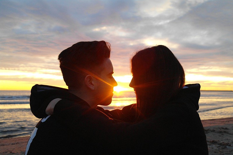 casal a olhar um para o outro durante o pôr do sol