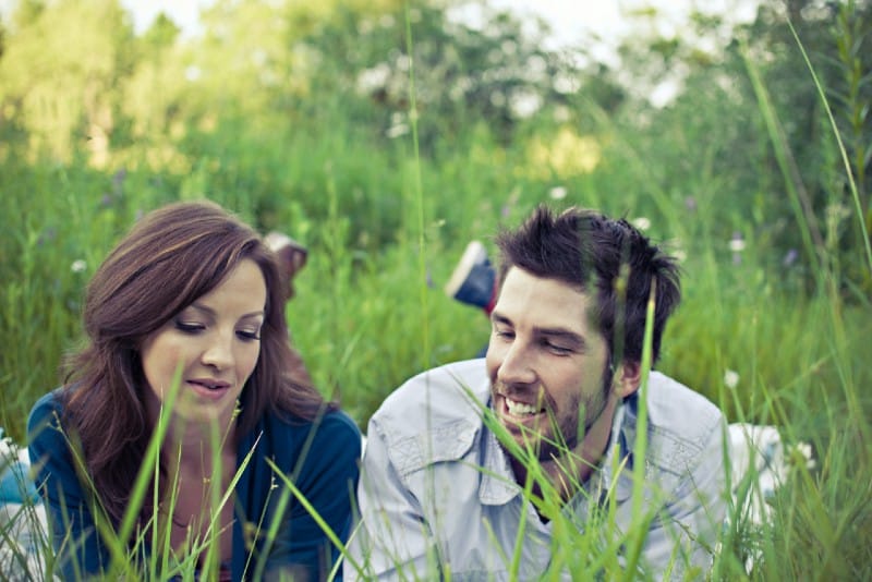 man and woman lying on grass and talking