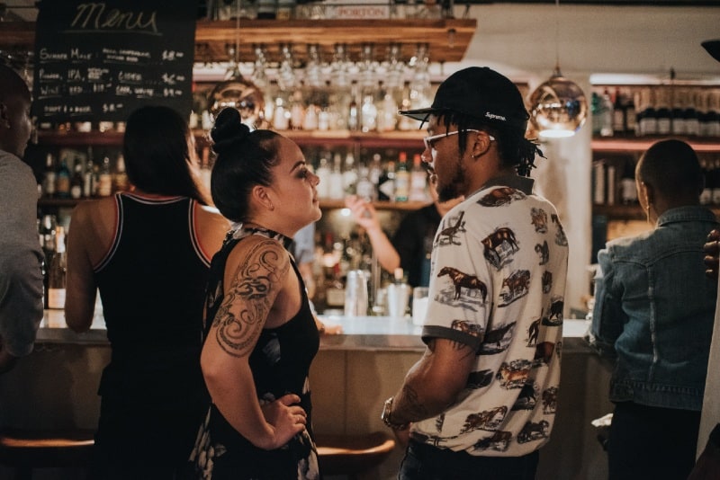 woman and man looking at each other at bar