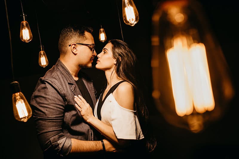 couple on nose to nose with incandescent lights around