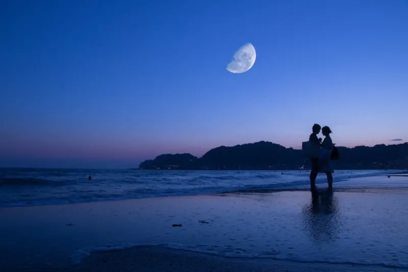 man and woman standing on beach 
