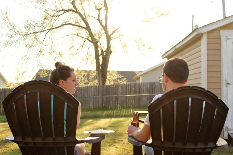 woman and man sitting on chairs backyard