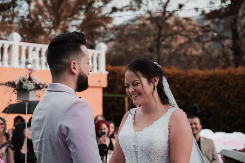 groom and bride smiling and standing outdoor