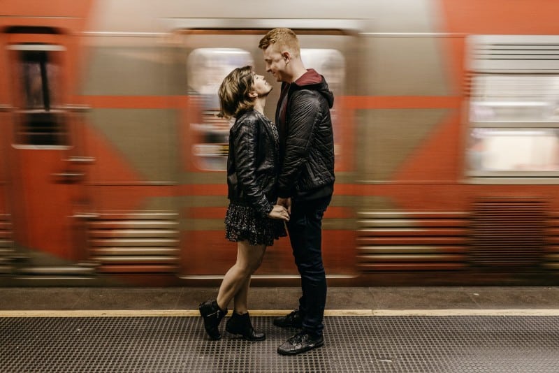 donna e uomo che si tengono per mano al passaggio del treno