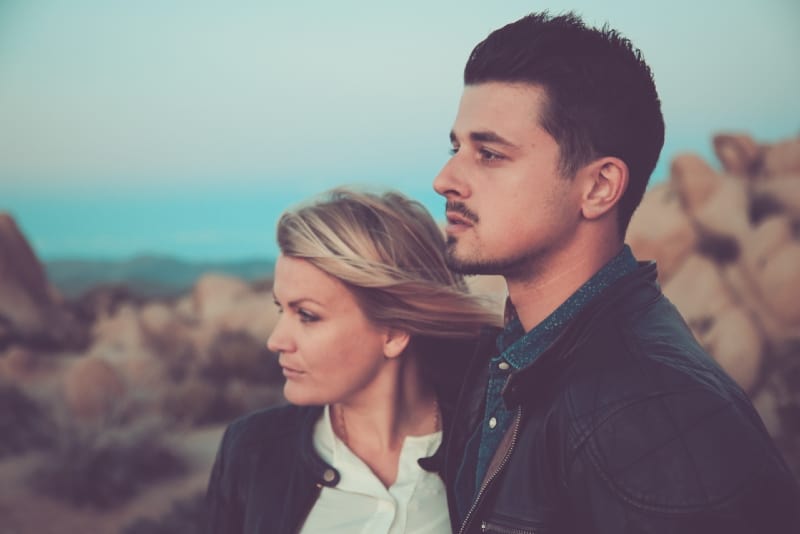 mujer rubia y hombre de pie al aire libre