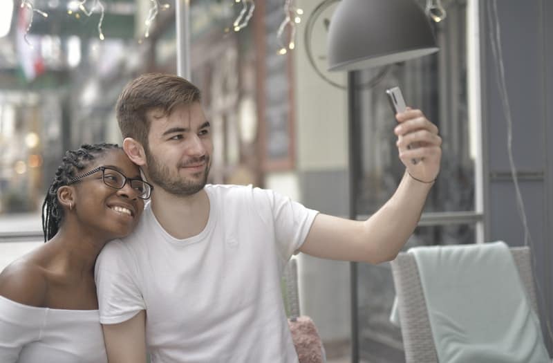 casal a tirar uma fotografia com um telemóvel 