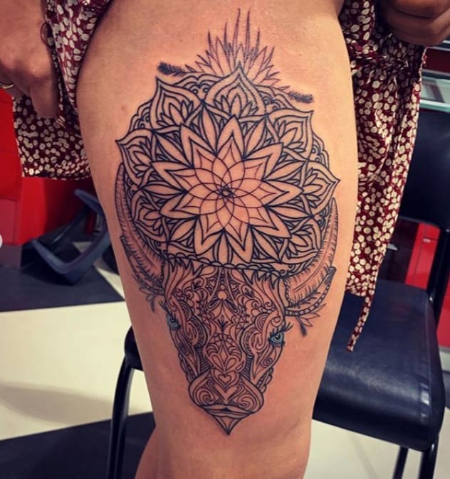 detailed taurus tattoo with mandala on the thigh