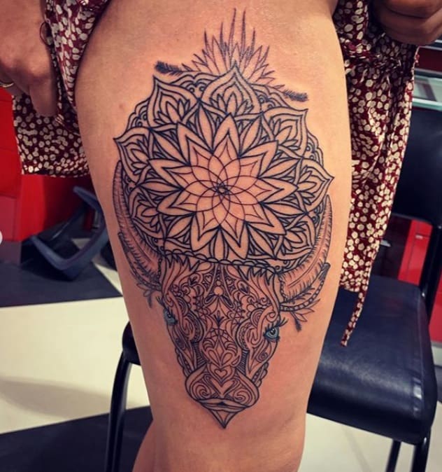 tatuagem de touro pormenorizada com mandala na coxa