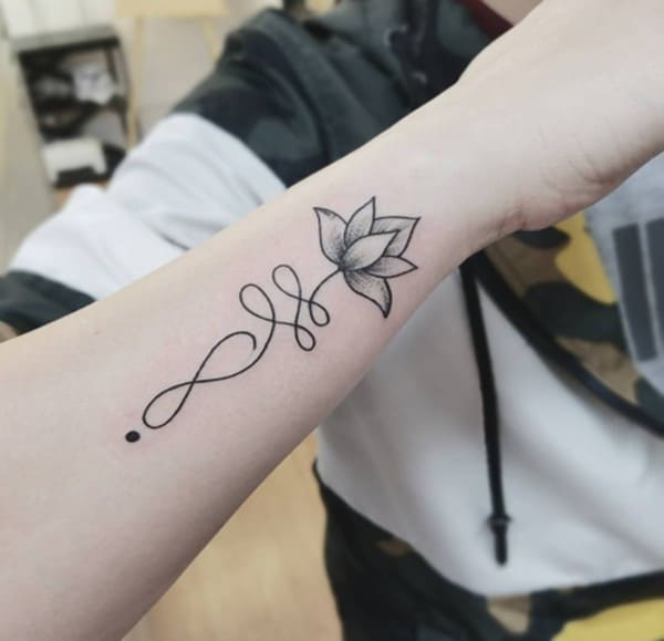 tatuaggio doppio infinito con illustrazione di loto sul braccio