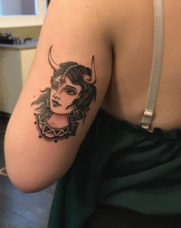 dreamy taurus girl tattoo on the upper arm