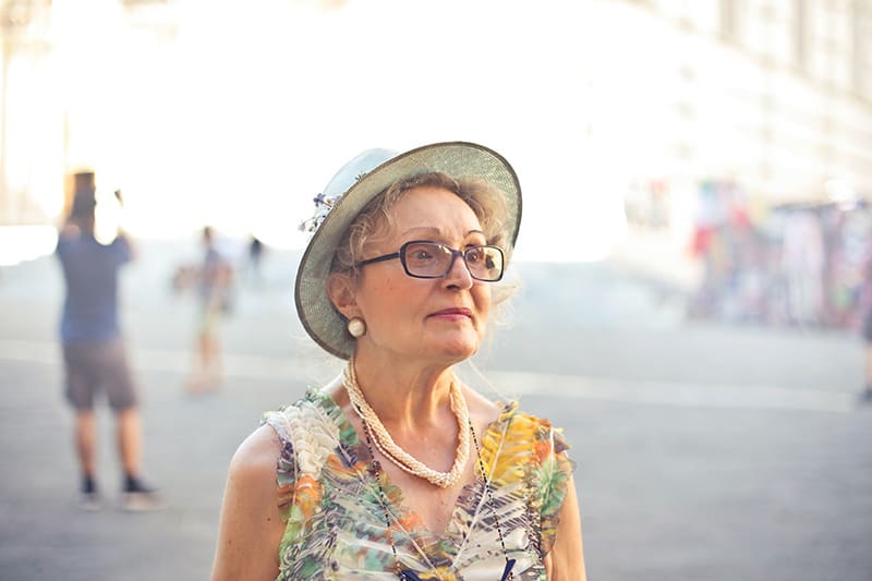 donna anziana con cappello e camicetta colorata