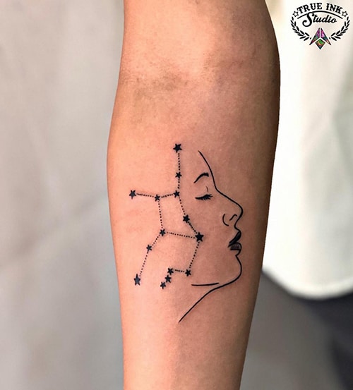 face profile and Virgo constellation with stars tattoo on the forearm
