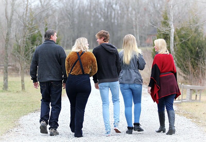 família a caminhar num caminho de gravilha durante o dia