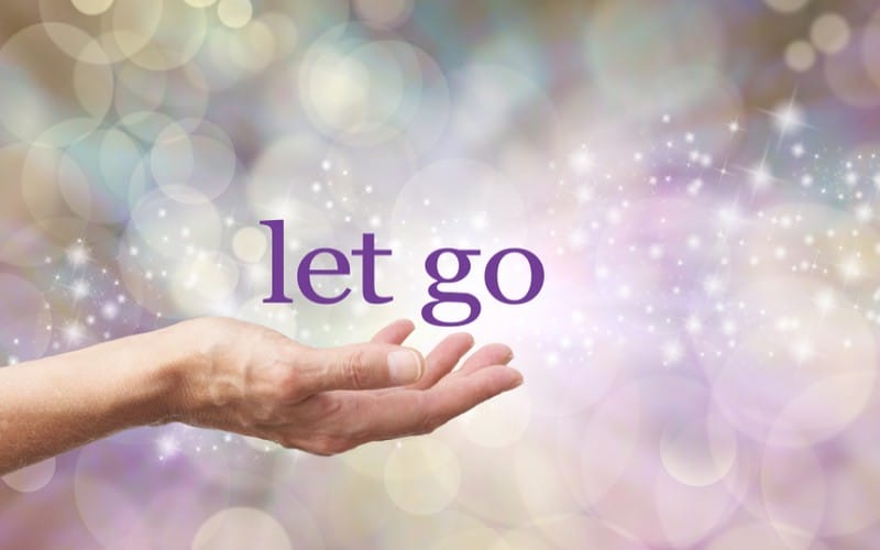 Female open hand with the words LET GO above against a sparkling background