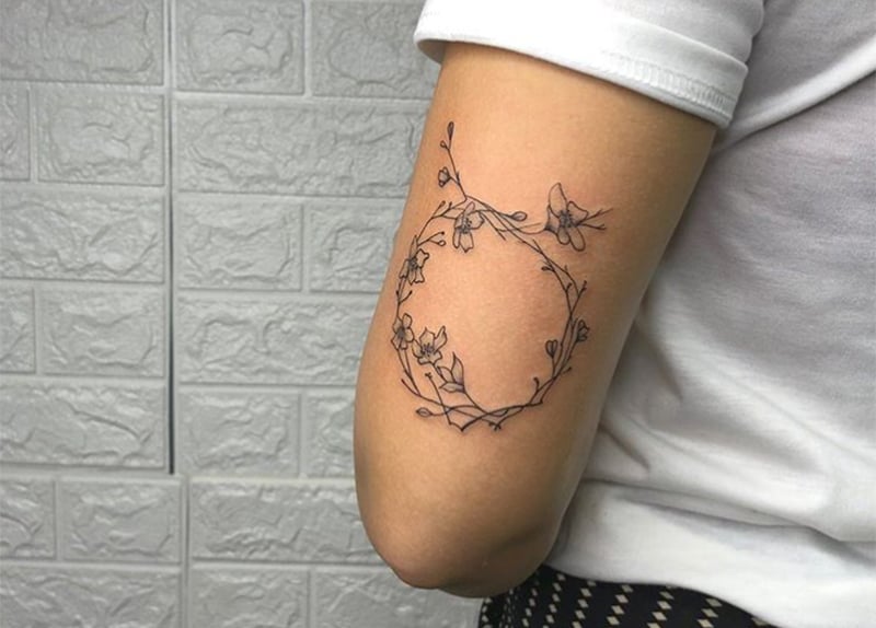 tatuagem de coroa de flores com a forma do símbolo do touro.