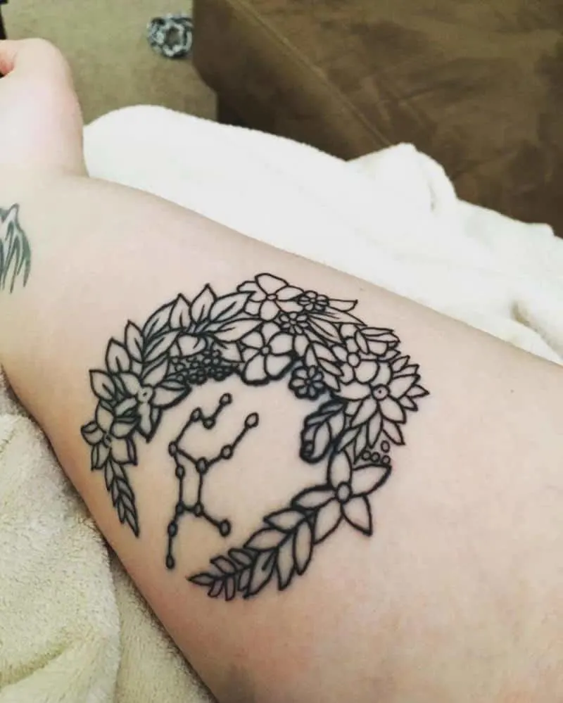 flower wreath tattoo with Virgo constellation inside it