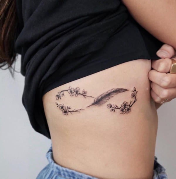 flowers and feather side rib tattoo