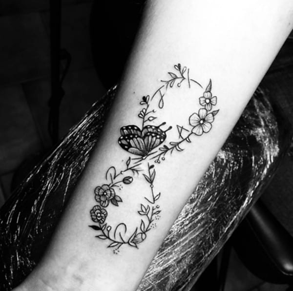 flowery tattoo with butterfly in the center on arm