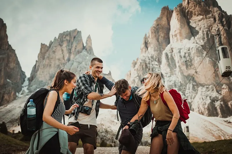 four persons laughing while hiking
