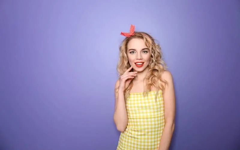 Funny blonde woman standing against purple background