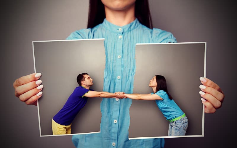 chica sosteniendo la foto rota de una pareja de enamorados que siguen cogidos de la mano