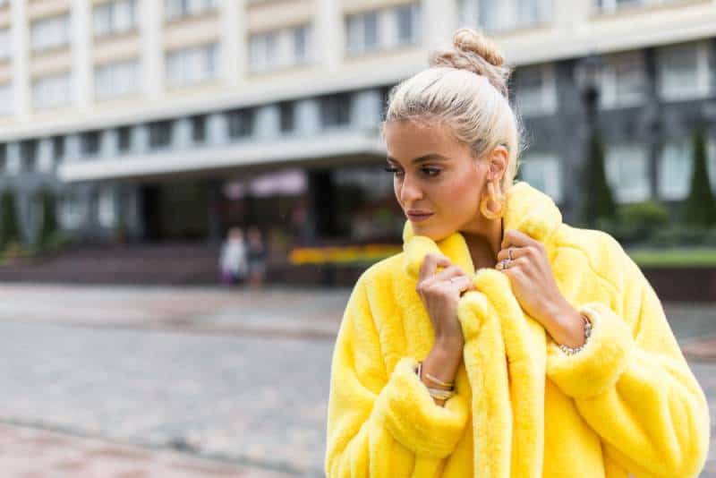 chica caminando al aire libre con un moderno abrigo amarillo