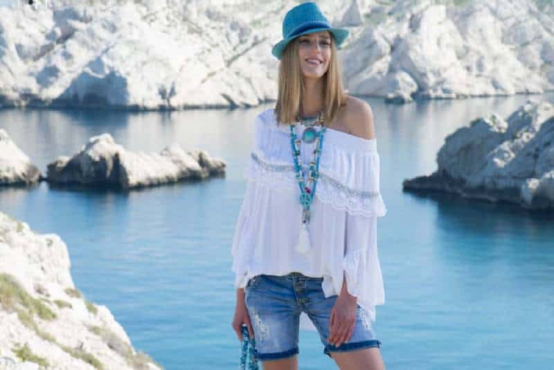 ragazza con top e pantaloncini bianchi in piedi su uno specchio d'acqua