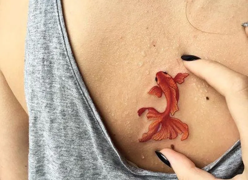 goldfish pisces tattoo on the back