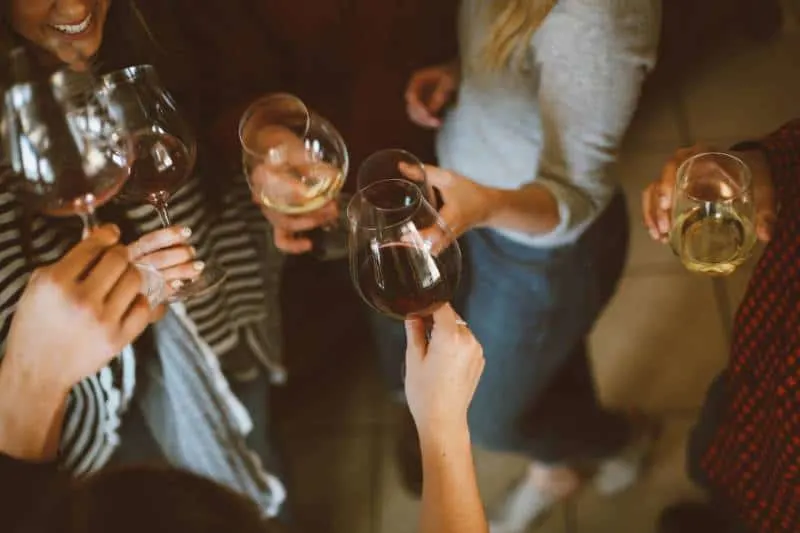 group of friends cheering with glasses of wine