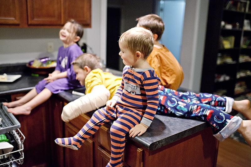 gruppo di bambini seduti sul tavolo della cucina mentre ridono